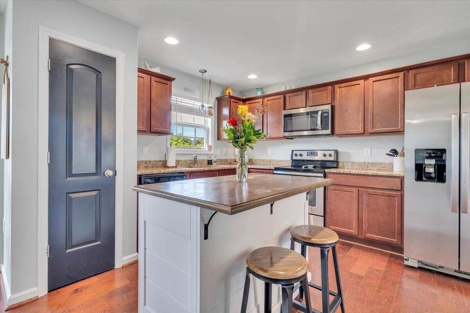 522 Cambridge Ct Road Vinton, VA 24179 - Photo 7 of 32 a kitchen with stainless steel appliances granite countertop a sink a stove a refrigerator cabinets and a dining table with wooden floor