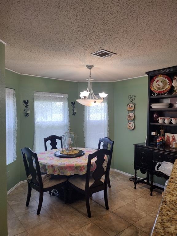 4617 Lexington Street Waco, TX 76705 - Photo 11 of 14 Dining area featuring a textured ceiling, a chandelier, and tile patterned flooring