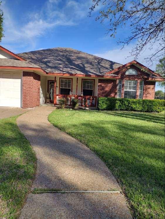 4617 Lexington Street Waco, TX 76705 - Photo 4 of 14 Ranch-style home with covered porch, a front yard, brick siding, a shingled roof, and an attached garage