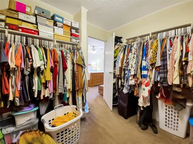 a view of walk in closet with clothes and shoes