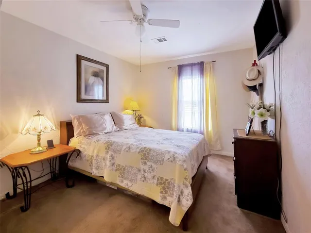 a bedroom with a bed and a lamp on dresser