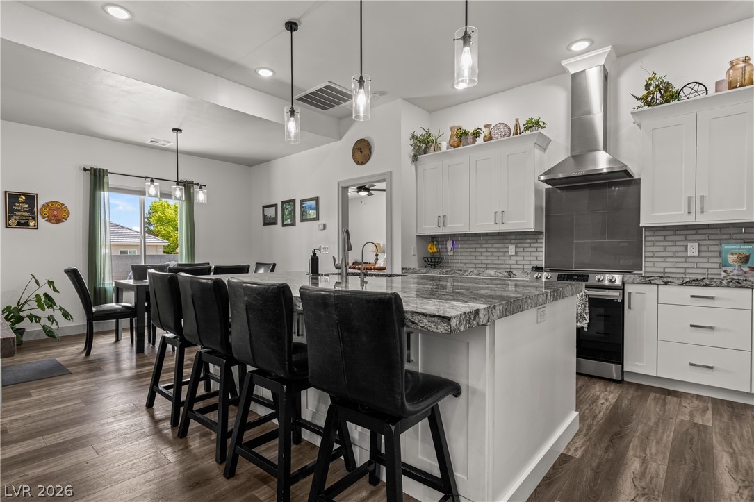 3020 Hannig Street Logandale, NV 89021 - Photo 18 of 75 An inviting open-concept kitchen features a spacious island with granite countertops and modern pendant lighting.