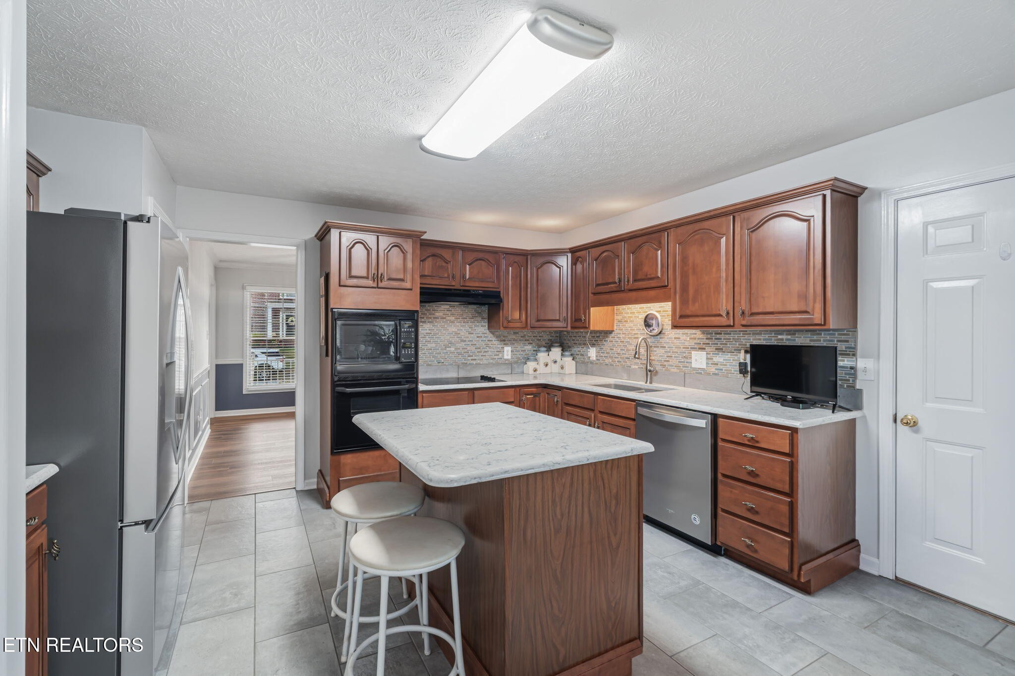 7030 Westerly Winds Road Knoxville, TN 37931 - Photo 18 of 40 a kitchen with stainless steel appliances granite countertop a refrigerator and a stove top oven