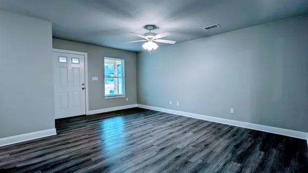 wooden floor in an empty room with a window