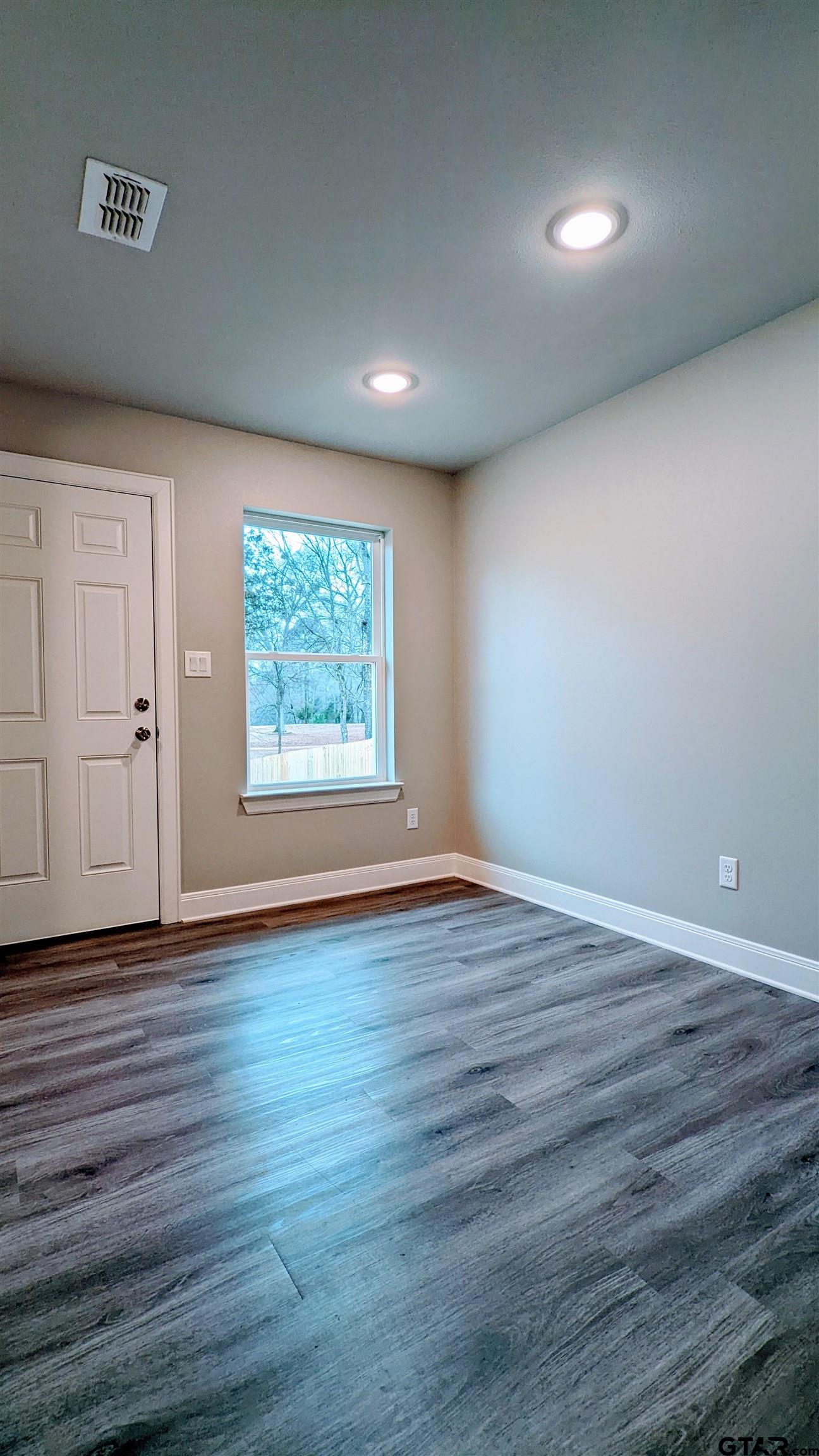 11672 Fm 2015, Unit B Tyler, TX 75708 - Photo 13 of 16 an empty room with wooden floor and windows