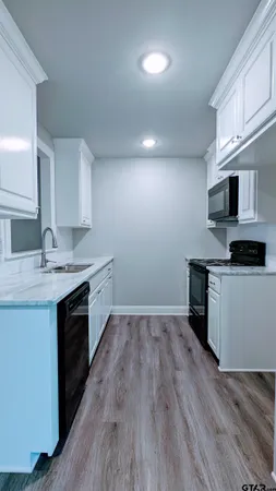 a kitchen with a sink cabinets and wooden floor