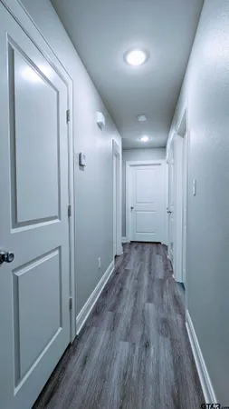 a view of a hallway with wooden floor