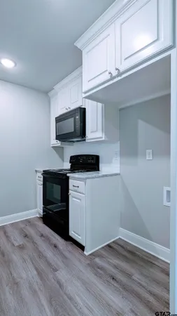 a kitchen with granite countertop a stove and a microwave