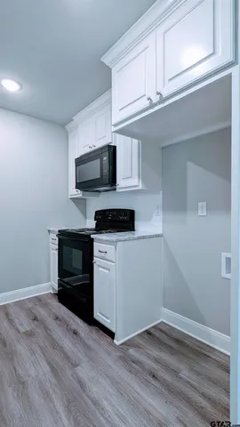 a kitchen with granite countertop a stove and a microwave