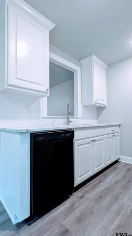 a kitchen with granite countertop white cabinets and a sink