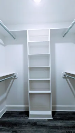 a view of walk in closet with empty racks