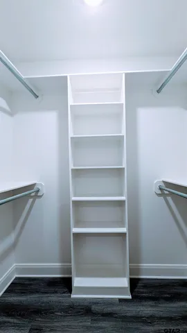 a view of walk in closet with empty racks