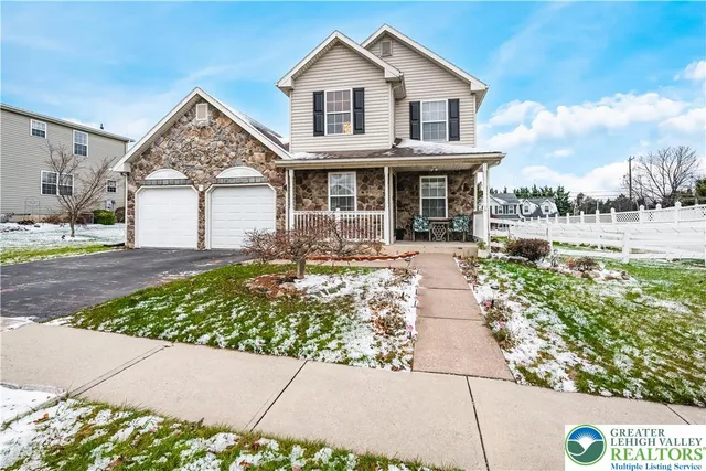 a view of a white house with a large windows next to a yard