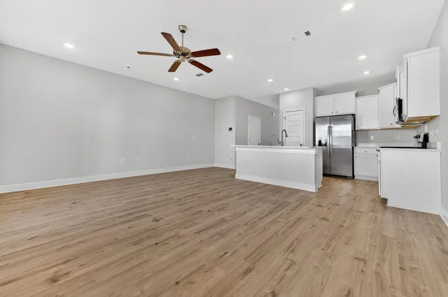 a view of empty room with wooden floor and window
