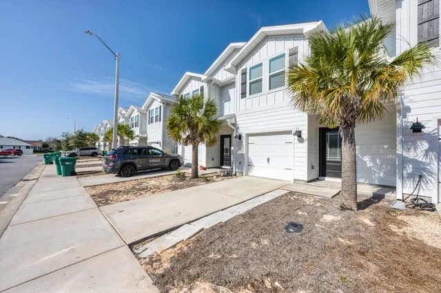 a view of a house with a yard and potted plants