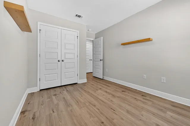 a view of an empty room with wooden floor