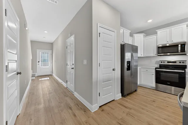 a view of a kitchen with wooden floor and electronic appliances