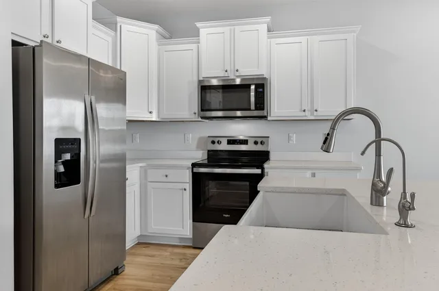 a kitchen with stainless steel appliances kitchen island a refrigerator sink and microwave