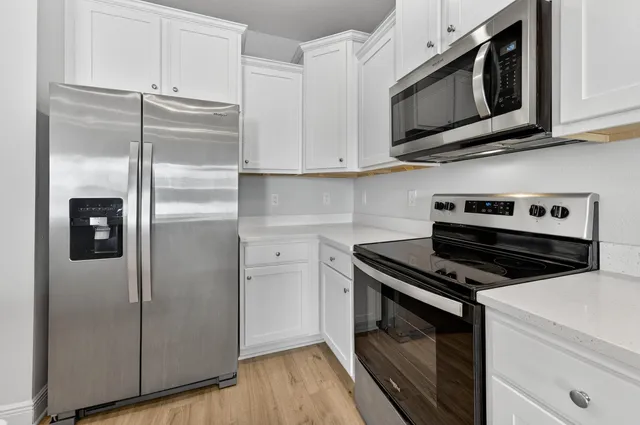 a kitchen with stainless steel appliances granite countertop a refrigerator microwave and sink