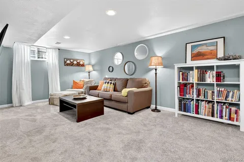a view of a patio with table and chairs potted plants and floor to ceiling window