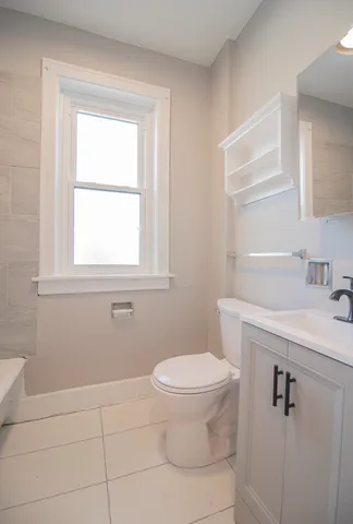a bathroom with a sink toilet and window