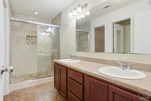 a bathroom with a sink shower and a mirror