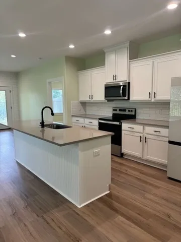 a kitchen with granite countertop a sink and cabinets