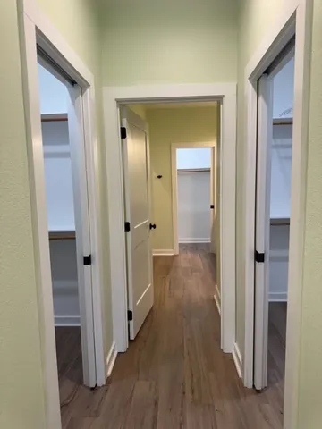 a view of a hallway with wooden floor