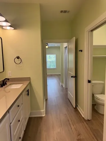 a bathroom with a granite countertop sink mirror vanity and toilet