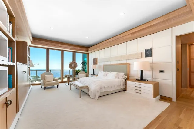 a bedroom with a bed couch and large window