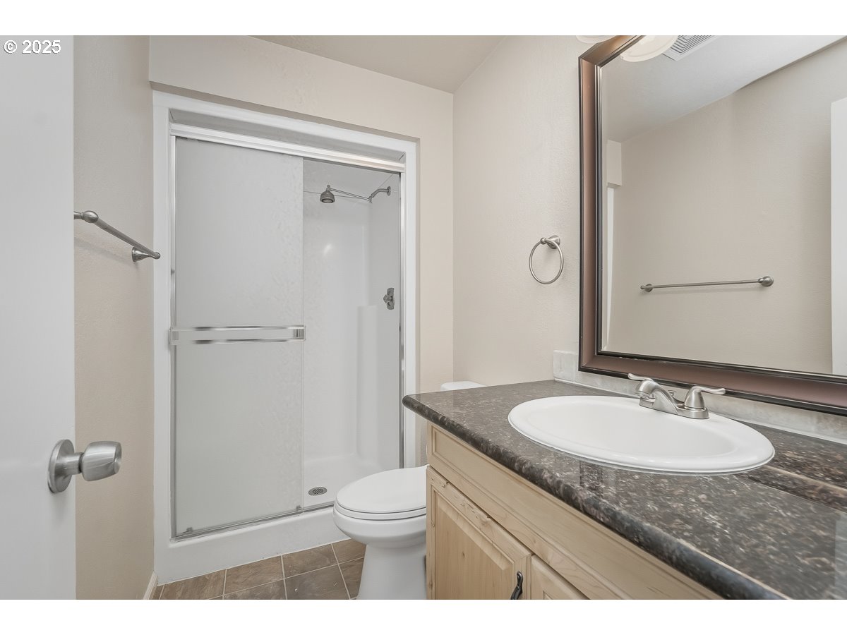 3247 Southeast Hathaway Drive Corvallis, OR 97333 - Photo 13 of 28 a bathroom with a granite countertop sink toilet and shower