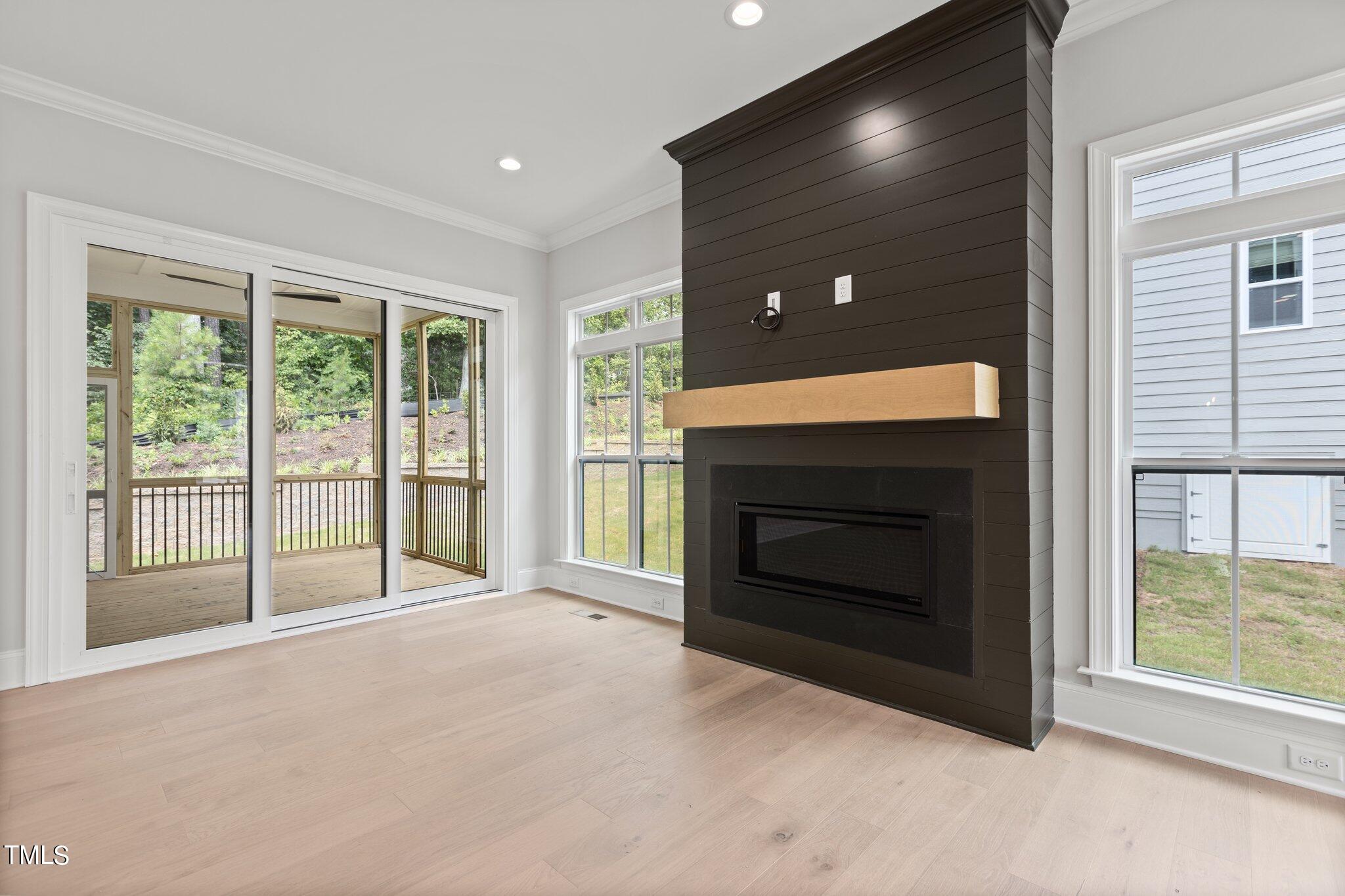9313 Field Maple Court Raleigh, NC 27613 - Photo 7 of 53 a view of an empty room with a fireplace and a large window