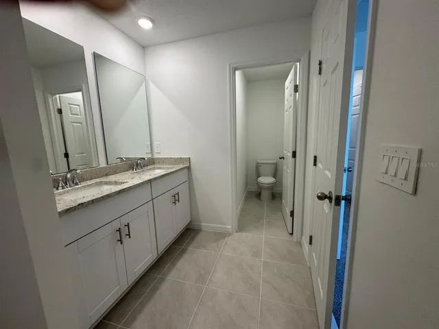 a spacious bathroom with a double vanity sink and mirror