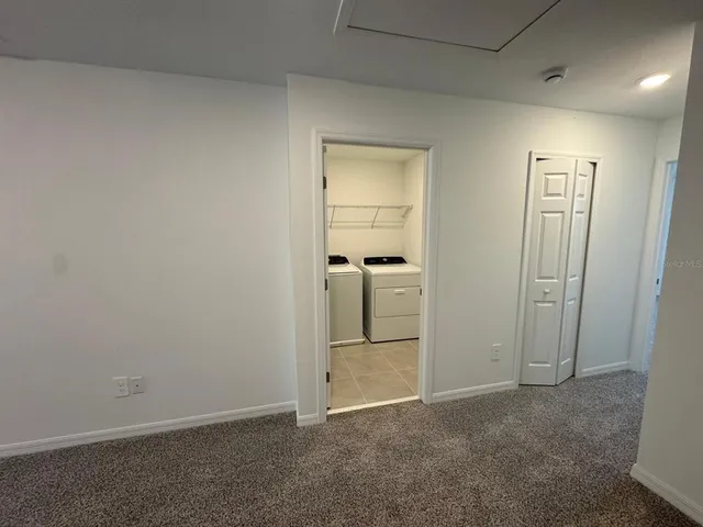 an empty room with closet and mirror