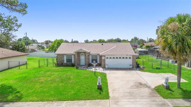 a view of a house with a yard and potted plants