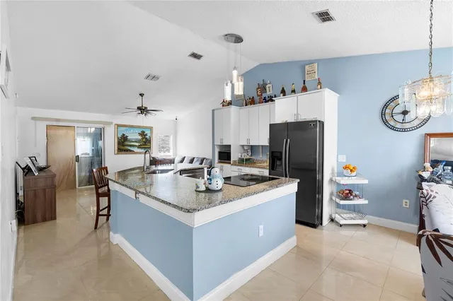 a kitchen with a sink a refrigerator and wooden cabinets