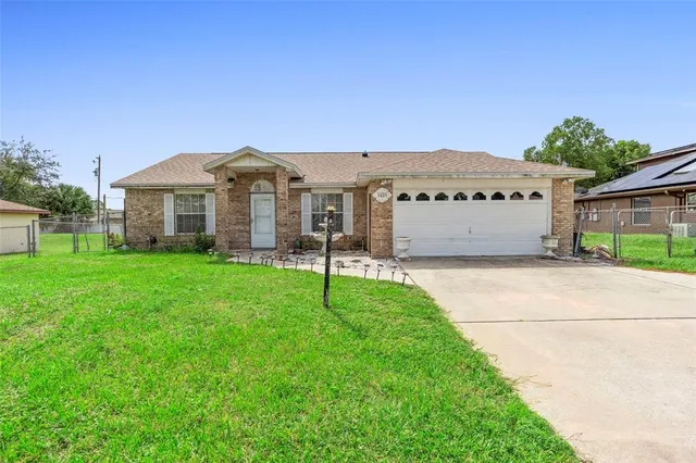 a view of a house with a big yard and large tree