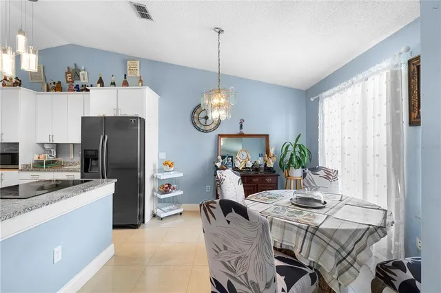 a view of kitchen with sink refrigerator dining table and chairs