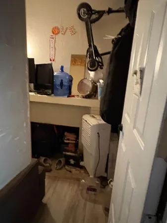 a view of a workspace room with wooden floor and a window