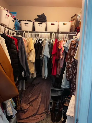a view of walk in closet with clothes and shoes