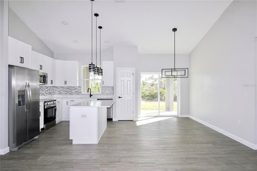 7335 Domenico Street Sebring, FL 33872 - Photo 15 of 38 a kitchen with stainless steel appliances granite countertop a refrigerator a sink dishwasher a stove and a wooden floors