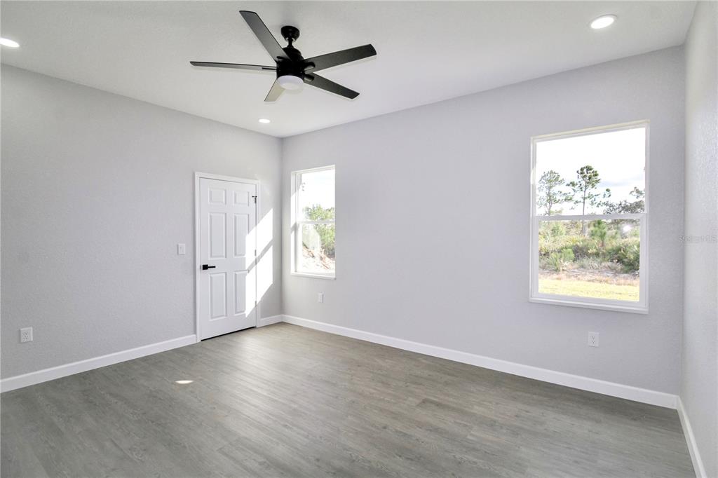 7335 Domenico Street Sebring, FL 33872 - Photo 17 of 38 an empty room with wooden floor and windows
