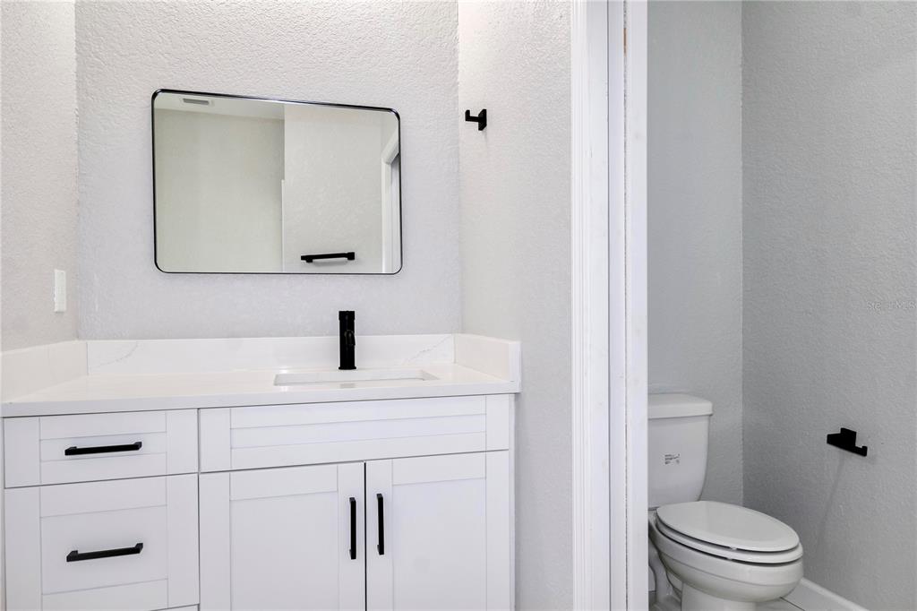 7335 Domenico Street Sebring, FL 33872 - Photo 20 of 38 a bathroom with a toilet sink vanity and mirror