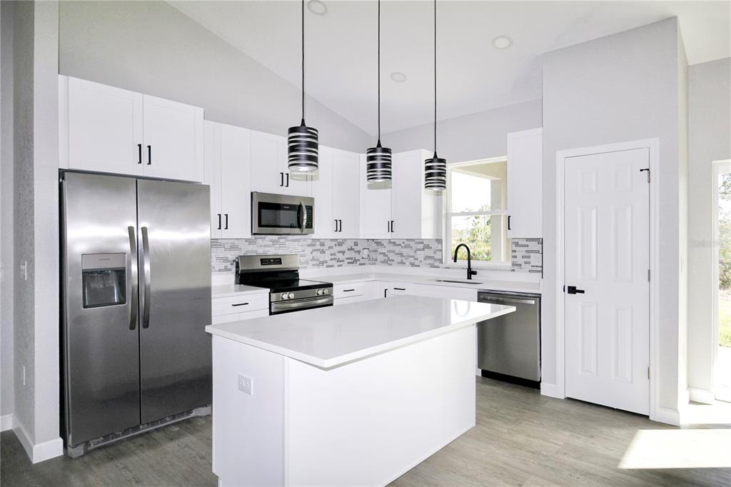 7335 Domenico Street Sebring, FL 33872 - Photo 2 of 38 a kitchen with stainless steel appliances a refrigerator sink and stove