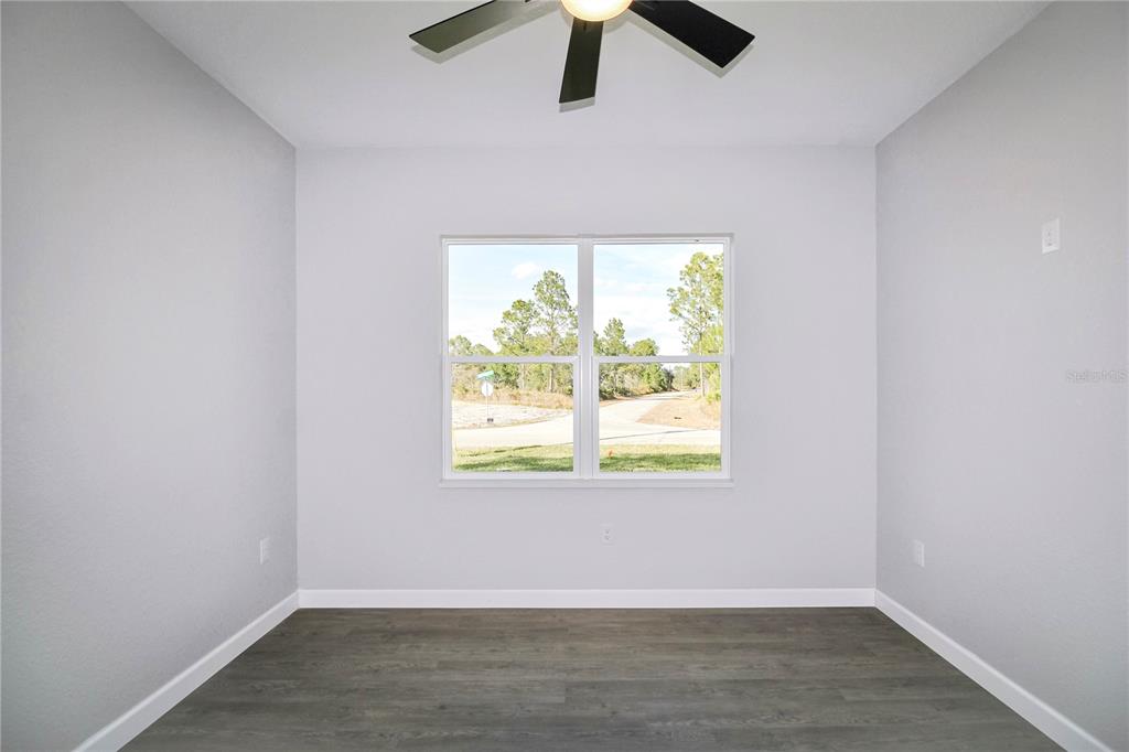 7335 Domenico Street Sebring, FL 33872 - Photo 27 of 38 an empty room with wooden floor and windows