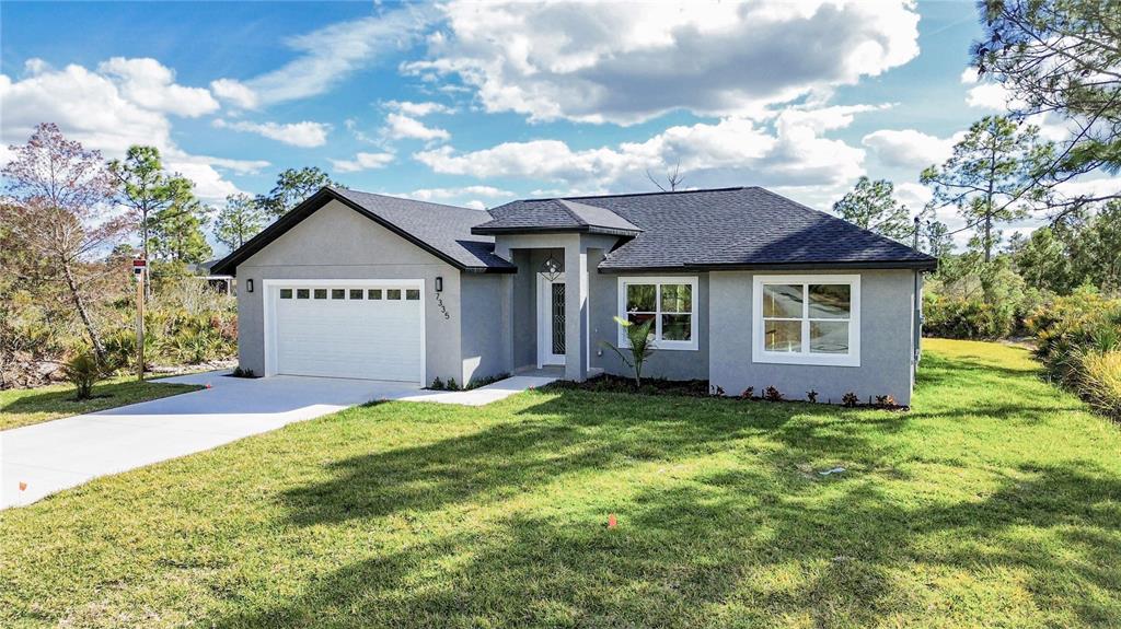 7335 Domenico Street Sebring, FL 33872 - Photo 7 of 38 a front view of a house with a yard and garage
