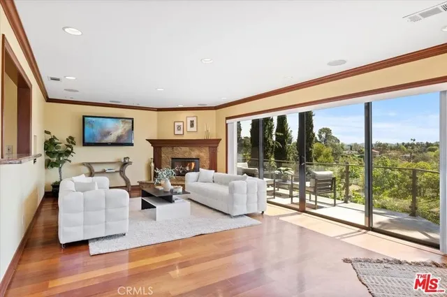 a living room with fireplace furniture and a large window