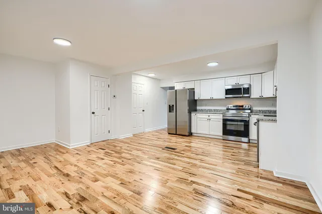 a large kitchen with kitchen island a sink stainless steel appliances and cabinets