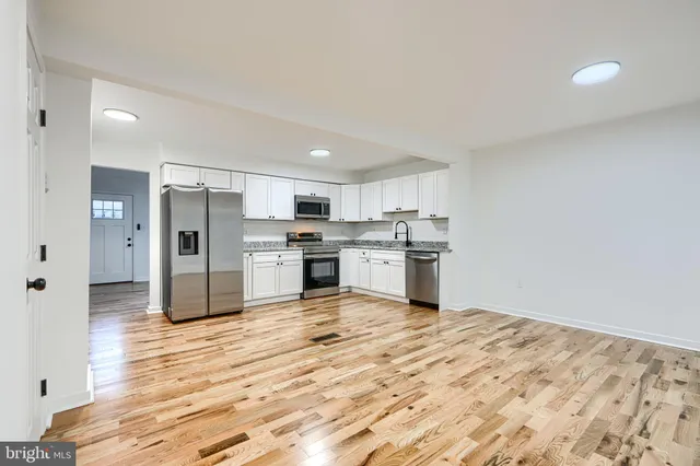 a kitchen with stainless steel appliances kitchen island granite countertop a refrigerator and a stove top oven