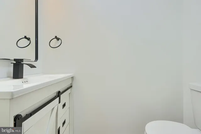 a bathroom with a sink a toilet and mirror